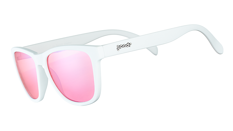 Vista de tres cuartos de unas gafas de sol blancas de forma cuadrada con cristales tintados en rosa antirreflectantes.