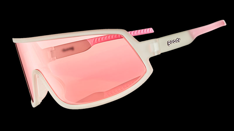 Vista di tre quarti di occhiali da sole avvolgenti con montatura trasparente e lente singola non riflettente color rosa.