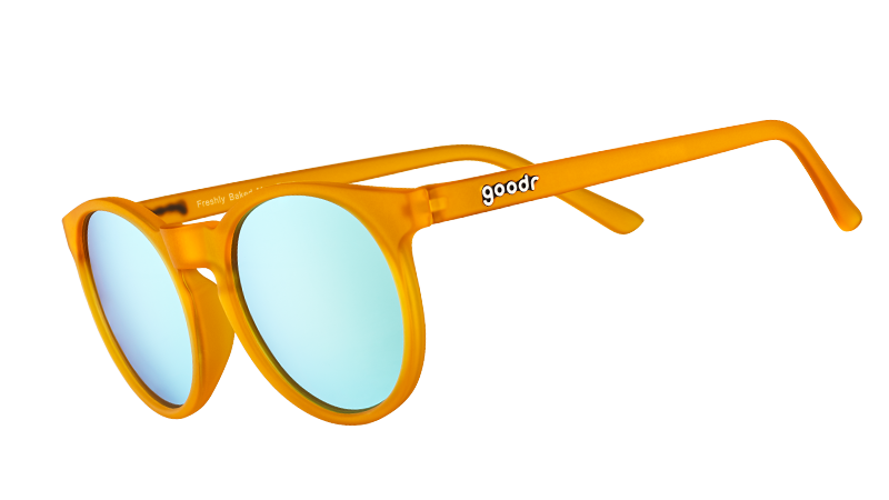 Vue de trois quarts de lunettes de soleil rondes de couleur orange, dotées de verres polarisés réfléchissants bleu clair.