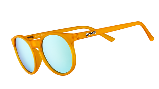 Vista di tre quarti di occhiali da sole rotondi arancioni con lenti polarizzate riflettenti blu chiaro.