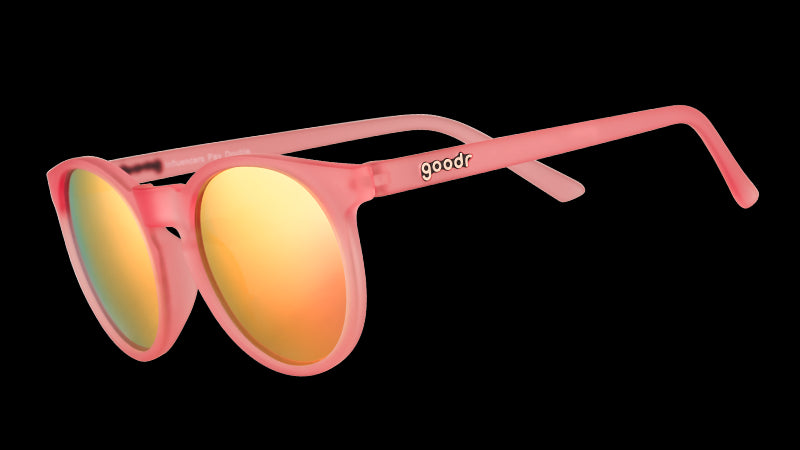 Vista en ángulo de tres cuartos de unas gafas de sol redondas de color rosa con cristales polarizados espejados de color rosa.
