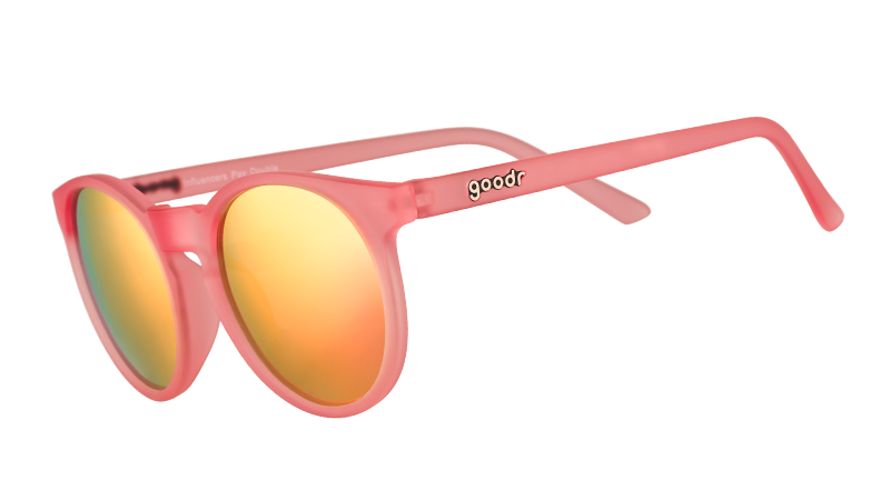 Vista en ángulo de tres cuartos de unas gafas de sol redondas de color rosa con cristales polarizados espejados de color rosa.