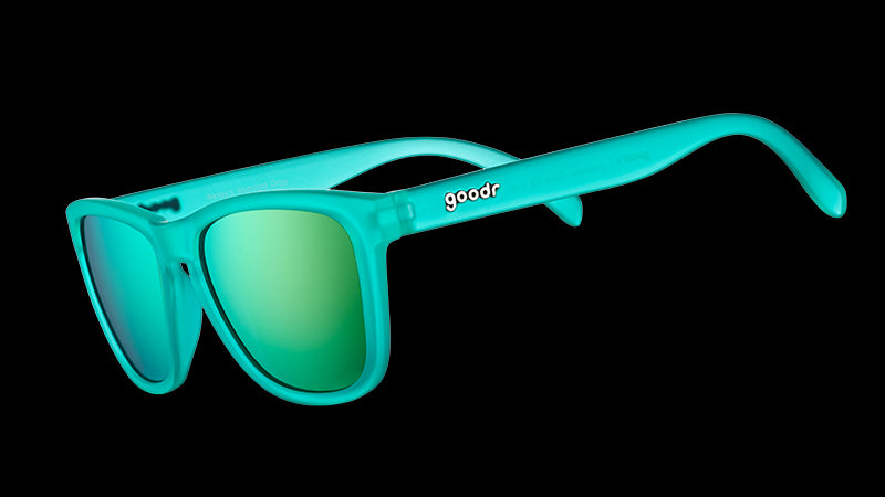 Vista en ángulo de tres cuartos de unas gafas de sol cuadradas de color verde azulado con lentes polarizadas reflectantes de color verde azulado.