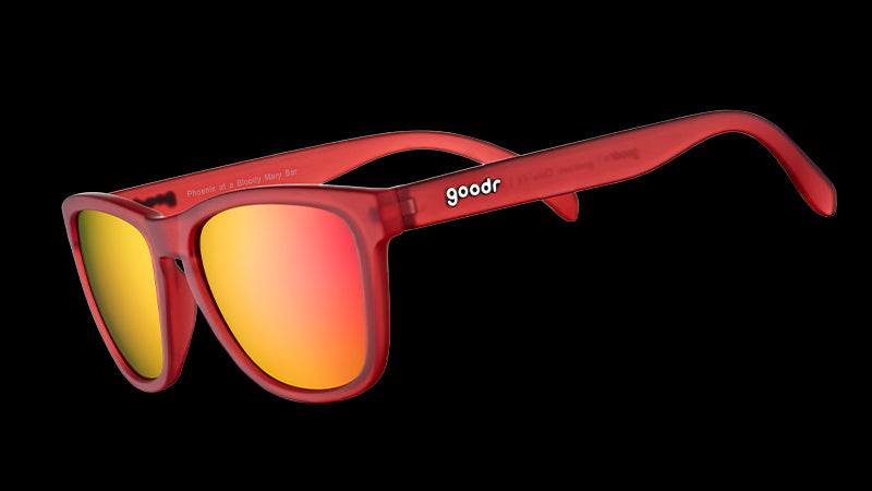 Dreiviertelansicht einer quadratischen Sonnenbrille mit rot-transparentem Rahmen und roten, reflektierenden Gläsern.