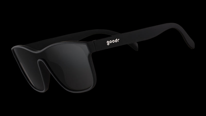 Vista en ángulo de tres cuartos de unas gafas de sol negras de aspecto futurista con lente única plana negra antirreflejos.
