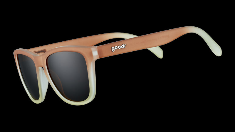 Vue de trois quarts d'angle de lunettes de soleil de forme carrée avec des montures dégradées de brun à blanc et des verres bruns non réfléchissants.