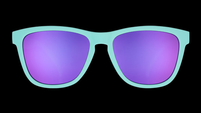 Vista frontal de unas gafas de sol cuadradas de color azul bebé con cristales morados reflectantes.