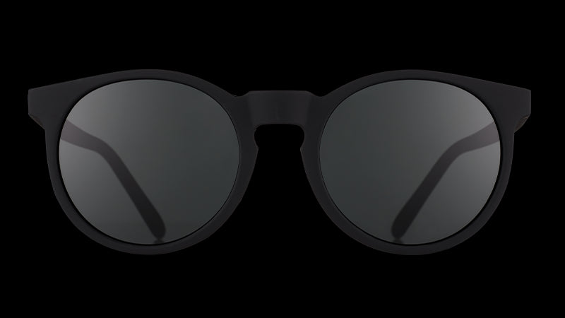 Vista frontale di occhiali da sole rotondi neri con lenti nere non riflettenti.