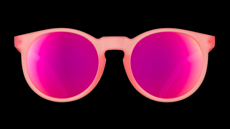 Vista frontal de unas gafas de sol redondas de color rosa con cristales polarizados reflectantes de color rosa.